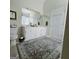 Bathroom with neutral-toned walls, white vanity with framed mirror, and a decorative rug at 248 Valley Way, Hampton, GA 30228