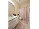 Neutral bathroom with a shower/tub combo, vanity, floral shower curtain, and matching rugs at 248 Valley Way, Hampton, GA 30228