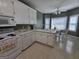 Well-lit kitchen featuring white appliances, white cabinets, and a cozy breakfast nook at 248 Valley Way, Hampton, GA 30228