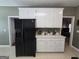 Kitchen featuring black refrigerator and white cabinets with ample counter space at 248 Valley Way, Hampton, GA 30228
