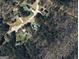 An aerial view of the property showing it's location relative to the neighborhood and surrounding wooded areas at 1022 Miss Amber Way, Locust Grove, GA 30248