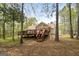 Back exterior view showcases the deck and the peaceful wooded surroundings at 1022 Miss Amber Way, Locust Grove, GA 30248