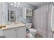Bright bathroom features a vanity, toilet, and a shower/tub combo with a patterned curtain at 1022 Miss Amber Way, Locust Grove, GA 30248