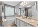 Bright bathroom featuring a double sink vanity, a soaking tub, and neutral gray colored walls at 1022 Miss Amber Way, Locust Grove, GA 30248