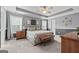 Spacious bedroom with tray ceiling, carpet flooring, and windows with natural light at 1022 Miss Amber Way, Locust Grove, GA 30248