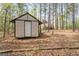 Outbuilding nestled among mature trees offers extra storage space and possibilities at 1022 Miss Amber Way, Locust Grove, GA 30248