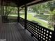 Covered porch with latticework railing offers a view of the lush landscape and walking path at 20 Fairway Ln, Peachtree City, GA 30269