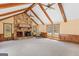 A cozy living room features a striking stone fireplace, wood beams, and large windows offering natural light at 426 Old Senoia Rd, Fayetteville, GA 30215