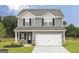 Charming two-story home featuring gray siding, black shutters, and a two-car garage at 301 Limestone Circle, Conyers, GA 30013