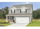 Charming two-story home featuring gray siding, black shutters, and a two-car garage at 301 Limestone Circle, Conyers, GA 30013