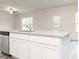Kitchen island featuring a stainless steel dishwasher, granite countertops, a sink, and white cabinets at 301 Limestone Circle, Conyers, GA 30013