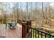 Inviting back deck featuring an outdoor dining area, overlooking peaceful wooded scenery and natural backdrop at 801 Streamside Dr, Mcdonough, GA 30252