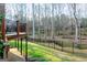 View of the large deck from the backyard showcasing a blend of manicured lawn, a fenced perimeter, and mature trees at 801 Streamside Dr, Mcdonough, GA 30252