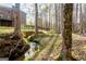 Lush backyard with a meandering creek, surrounded by mature trees, offering a serene, natural setting at 801 Streamside Dr, Mcdonough, GA 30252