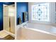 Beautiful bathroom features a stained glass window and soaking tub at 801 Streamside Dr, Mcdonough, GA 30252