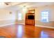 Open living room with hardwood floors, built-in cabinet, television and natural light at 801 Streamside Dr, Mcdonough, GA 30252