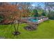 Aerial view of a backyard featuring a pool and house, surrounded by lush trees at 85 Bryan St, Mcdonough, GA 30253