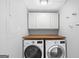 A well-lit laundry room featuring modern appliances and a practical wooden countertop at 85 Bryan St, Mcdonough, GA 30253