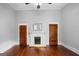 Living room featuring a fireplace and original hardwood floors, with natural light coming in from other rooms at 85 Bryan St, Mcdonough, GA 30253