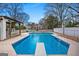 Backyard pool with diving board, partially surrounded by a white fence and lush trees at 85 Bryan St, Mcdonough, GA 30253