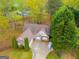 Aerial view of a brick home with mature trees, a manicured lawn, and a long driveway at 324 Sue Ct, Temple, GA 30179