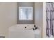 Close-up of the large soaking tub, window, and privacy curtain in the bathroom at 324 Sue Ct, Temple, GA 30179