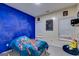 Bedroom features Injustice poster and bright blue accent wall at 324 Sue Ct, Temple, GA 30179