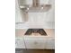 Modern range with stainless steel vent hood, white subway tile backsplash, and stone countertops at 3695 Andover St, Cumming, GA 30028