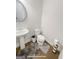 Charming powder room featuring hardwood floors, a pedestal sink, and a decorative round mirror at 3695 Andover St, Cumming, GA 30028