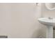 Clean half-bathroom featuring a pedestal sink, light neutral walls, and simple design for a functional space at 784 Brookside Parc Ln, Avondale Estates, GA 30002