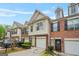 Inviting townhome with brick and siding, attached garage, and a neatly kept front yard under a partly cloudy sky at 784 Brookside Parc Ln, Avondale Estates, GA 30002