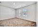 A carpeted bedroom features a window that allows plenty of natural light to illuminate the space at 328 Wandering Brook Dr # 39, Mcdonough, GA 30253