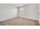 A carpeted bedroom features a window that allows plenty of natural light to illuminate the space at 328 Wandering Brook Dr # 39, Mcdonough, GA 30253