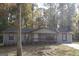 Cozy home featuring neutral siding and red trim, complemented by a yard with mature trees at 321 Summerwood Ln, Stockbridge, GA 30281