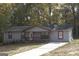 Charming single-story home featuring neutral siding, red window trim, and a cozy front porch at 321 Summerwood Ln, Stockbridge, GA 30281