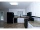 Well-lit kitchen featuring white cabinets, granite countertops, and modern black appliances at 321 Summerwood Ln, Stockbridge, GA 30281