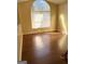 Bright bedroom featuring a large arched window, hardwood floors, and neutral decor at 5734 Wellborn Oaks Ct, Lithonia, GA 30058