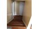 Interior staircase with hardwood steps and railing leading up to a landing and a white door at 5734 Wellborn Oaks Ct, Lithonia, GA 30058