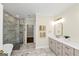 Spacious bathroom with a glass enclosed shower, tub, and marble countertops at 1188 Oakland Sw Ln, Atlanta, GA 30310