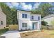 Charming two-story home with white brick and siding, blue door, modern windows, and fresh landscaping at 1188 Oakland Sw Ln, Atlanta, GA 30310