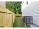 Side yard with a new wooden fence, green grass, and a modern HVAC system in black cage at 1188 Oakland Sw Ln, Atlanta, GA 30310