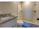 Bathroom with granite vanity, toilet, and tub-shower combination at 5122 Hillcrest Nw Dr, Covington, GA 30014