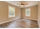 Bedroom with wood-look flooring, ceiling fan, and two windows at 5122 Hillcrest Nw Dr, Covington, GA 30014