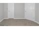Bedroom featuring neutral carpeting and walls and two white paneled doors at 6566 Chestnut Oaks Rdg, Lithonia, GA 30038