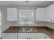 Bright kitchen features a stainless steel sink, a window and white cabinetry at 6566 Chestnut Oaks Rdg, Lithonia, GA 30038