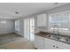 Eat-in kitchen with stainless steel sink, tan tile floor and access to living room at 6566 Chestnut Oaks Rdg, Lithonia, GA 30038
