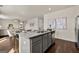 Open-concept kitchen featuring gray cabinets, a large island with granite countertops, and hardwood floors at 596 Whitman Lane # 2025, Stockbridge, GA 30281