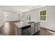 Open floor plan with an island sink and stainless dishwasher facing a brightly lit living room with many windows at 596 Whitman Lane # 2025, Stockbridge, GA 30281