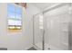 Bright bathroom shower with glass doors, a window view and new construction at 596 Whitman Lane # 2025, Stockbridge, GA 30281
