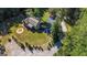Aerial view of a home with a circular driveway, surrounded by lush greenery and mature trees at 250 Hester Rd, Carrollton, GA 30116